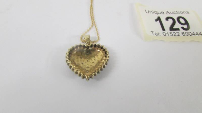 A yellow gold heart pendant on a 9ct gold chain. - Image 7 of 7