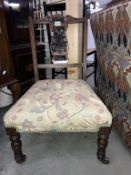 An Edwardian nursing chair with carved back and tapestry seat cover