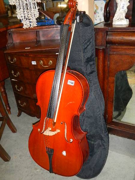 A cello with bow in soft case, (needs strings but in good condition).