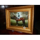 A gilt framed print of a racehorse.