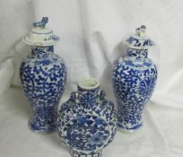 A pair of early Chinese blue and white lidded vases (both lids a/f) and a blue and white flask.