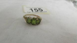 A ring set three large peridot, size R. (tests as gold).