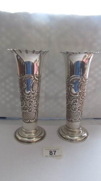 A pair of silver embossed vases.