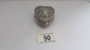 A heart shaped silver pill box.