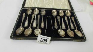 Two sets of six silver teaspoons and silver sugar tongs in case.