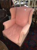A vintage wing arm chair with pink covering