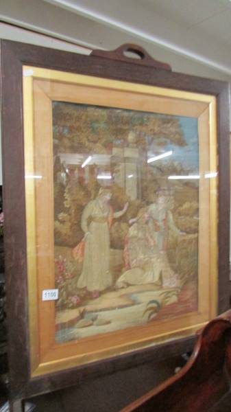 An oak firescreen with inset woolwork picture.