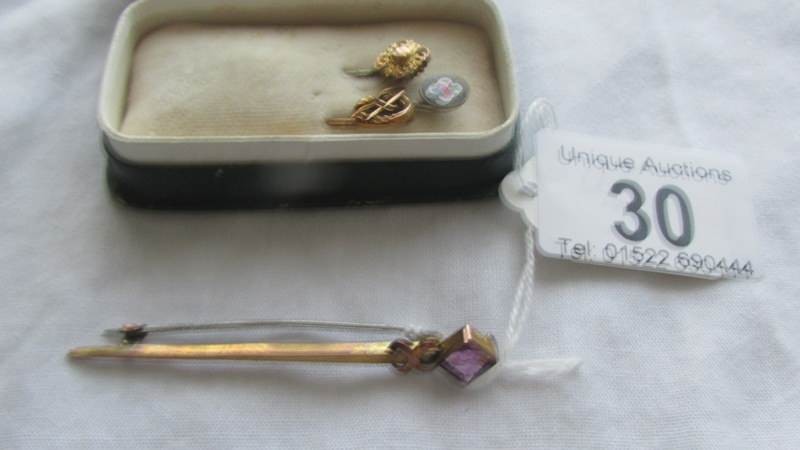 Three antique stick pins and a brooch including gold examples.