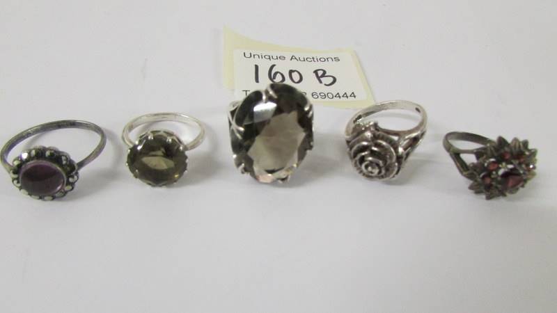 Five silver rings set various stones.