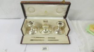 A cased Asprey fully hallmarked sterling silver writing garniture. Glass liner for ink well has a