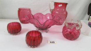 Six items of cranberry glass including jug, fruit bowl, biscuit jar (missing lid)etc.,