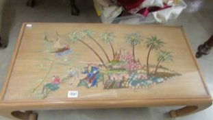 A glass topped coffee table with village scene.