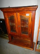 A two door glazed wall display cabinet.