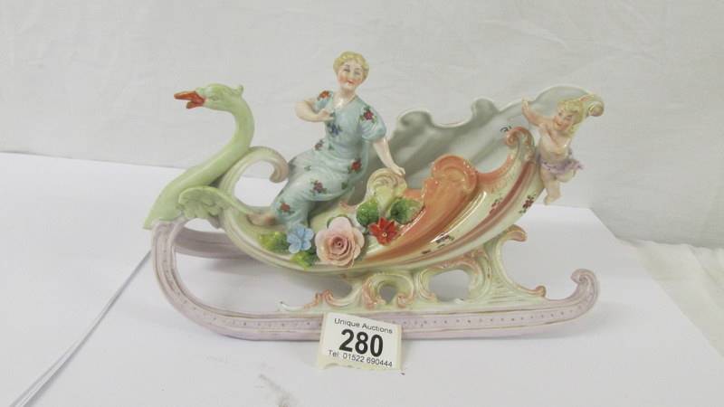 A porcelain swan carriage figure group.
