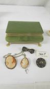 Two silver brooches, a cameo pendant and a cameo brooch in an onyx jewellery box.
