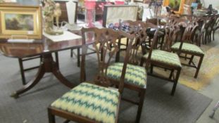 A good large old mahogany extending dining table with two leaves and ten chairs including 2 carvers.