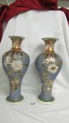 A pair of vases 13" high with mostly blue textures background on which is a lovely decoration of
