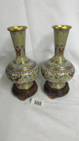 A pair of decorative Cloissonne vases on bases, vases 18cm tall, with bases 21.5cm tall.