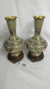 A pair of decorative Cloissonne vases on bases, vases 18cm tall, with bases 21.5cm tall.
