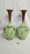 A pair of Doulton Slater narrow neck vases, 26 cm tall. (one has a small chip to base and