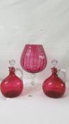 A pair of Cranberry glass flasks and a large glass goblet. Collect only.