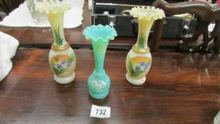 A pair of hand painted glass vases and one other.
