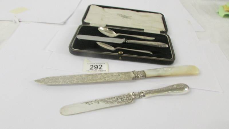 A silver cake knife with mother of pearl handle, a silver butter knife, two silver teaspoons and