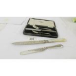 A silver cake knife with mother of pearl handle, a silver butter knife, two silver teaspoons and