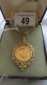 A 1911 full sovereign in a decorative gold mount with attached 9ct gold chain (chain 8.5 grams)
