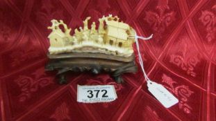 An antique carved ivory village scene on base. Available for UK shipping only.