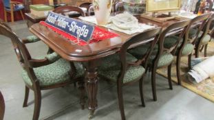 A mahogany extending dining table with 2 leaves and ten chairs including 2 carvers.