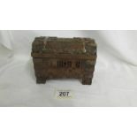 An intricately carved wooden money box with metal mounts, dated London 1936, in the arts and