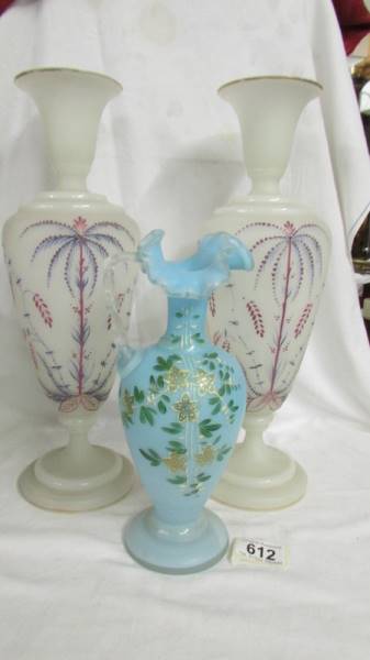 A pair of opaque hand painted glass vases,, 36 cm and a blue glass hand painted jug, 24 cm, all in