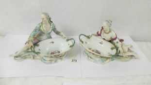 A pair of fine porcelain male and female figure/sweet meat dishes with crossed swords mark.