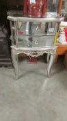 A good quality silver coloured mirrored cabinet.