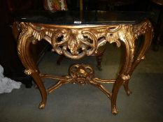 A gilded console table with marble top.