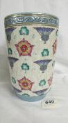 A wide Bursley ware vase by Charlotte Rhead. White dapple ground with blue thistles, red roses and