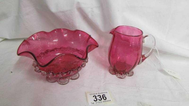A cranberry glass cream jug and sugar bowl.