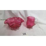 A cranberry glass cream jug and sugar bowl.