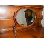 An oval mahogany toilet mirror.