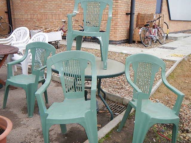 4 green plastic garden chairs, a parasol base and a table. Collect only.