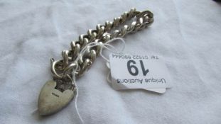 A silver bracelet with padlock.