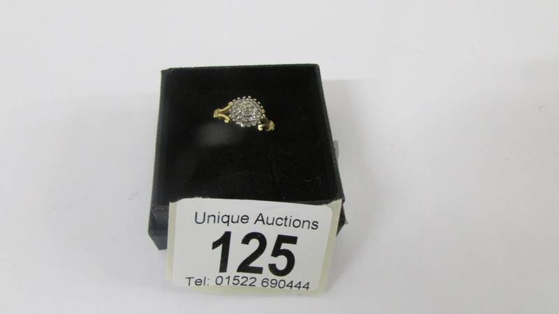 A 18ct floral diamond ring with two diamonds on sides. size H. Weight 3.8g