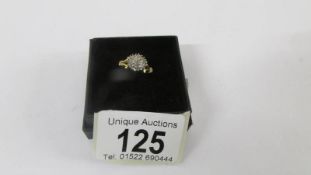 A 18ct floral diamond ring with two diamonds on sides. size H. Weight 3.8g
