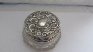 A silver topped glass powder bowl.