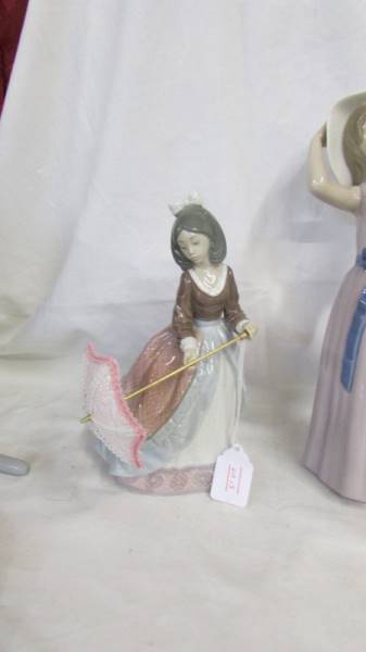 A Lladro figure of a girl with a parasol and another of a girl in hat. - Image 3 of 4