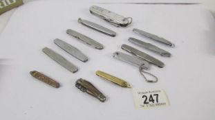 Twelve vintage penknives including advertising.