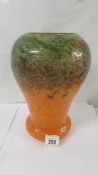 A 12" high Monart glass vase, bottom part orange and top green with golden flecks. No visible