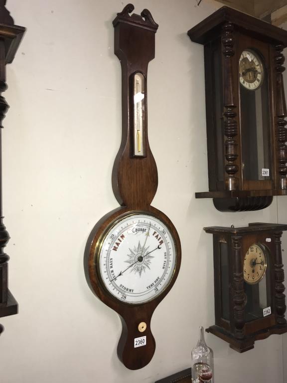 A Victorian Mahogany wheel barometer with porcelain dial and swan neck pediment Height 103cm (