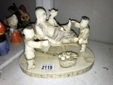 A resin oriental faux ivory figure group